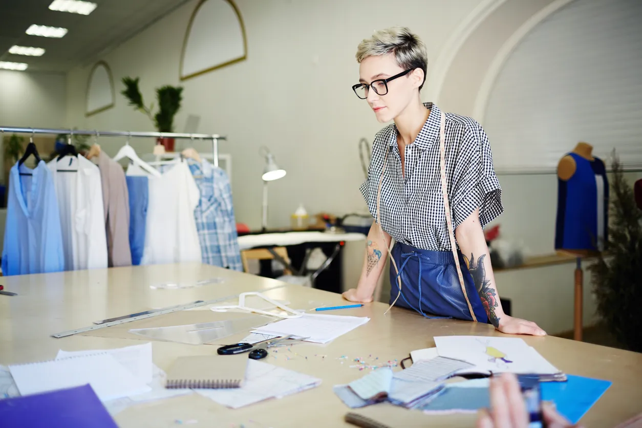 Diseñadora trabajando sobre patrones en un taller de confección
